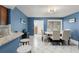 Stylish dining room with a modern table set, complemented by a chic rug and blue accent walls at 5365 Rocking Horse Pl, Oviedo, FL 32765