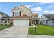 Inviting two-story home featuring a well-maintained lawn and attached two car garage with beautiful stone accents at 5365 Rocking Horse Pl, Oviedo, FL 32765