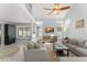 Bright living room with high ceilings, a ceiling fan, multiple windows, and two sofas with a staircase nearby at 5365 Rocking Horse Pl, Oviedo, FL 32765