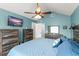 Spacious bedroom with blue bedding, rustic furniture, and a television for entertainment at 5365 Rocking Horse Pl, Oviedo, FL 32765