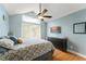 Cozy bedroom with a floral-patterned bedspread and a TV mounted on the wall at 5365 Rocking Horse Pl, Oviedo, FL 32765