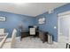 Well-lit office space features a sleek desk setup and a modern aesthetic with eye-catching blue walls at 5365 Rocking Horse Pl, Oviedo, FL 32765