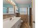 Bathroom with a vanity sink, framed mirror, tiled walls and a glass shower at 540 W Columbia St, Lake Alfred, FL 33850