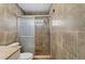 Tiled bathroom featuring a glass-enclosed shower, granite countertop, and modern fixtures at 540 W Columbia St, Lake Alfred, FL 33850