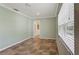 Well-lit bedroom featuring neutral walls, hard surface floors and a bright airy feel with a view to another room at 540 W Columbia St, Lake Alfred, FL 33850