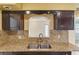Kitchen area featuring granite countertops, dark wood cabinets, and a stainless steel faucet at 540 W Columbia St, Lake Alfred, FL 33850