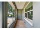 Enclosed porch with large windows providing natural light and views, tiled floors, and access to the front door at 540 W Columbia St, Lake Alfred, FL 33850