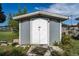 A gray storage shed featuring white double doors, providing ample space for outdoor tools and equipment at 540 W Columbia St, Lake Alfred, FL 33850
