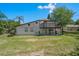 A view of the back of the property including a deck and patio area with green grass at 5420 Lido St, Orlando, FL 32807