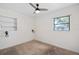 Cozy bedroom features carpeted floors, a ceiling fan, and a window overlooking the backyard at 5420 Lido St, Orlando, FL 32807