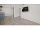 Open concept living space with wood-look tile flooring, a mounted TV, and an open view to kitchen at 5420 Lido St, Orlando, FL 32807