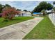 Picture of house with light blue trim and long drive way with mature pink tree at 6026 Canyon De Chelley Ct, Orlando, FL 32810