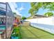 Enclosed backyard featuring a putting green, storage shed, colorful yard art, and view of neighboring houses at 680 Cheoy Lee Cir, Winter Springs, FL 32708