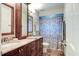 Bathroom features a double vanity with granite countertops, matching mirrors, and a tiled shower with glass door at 680 Cheoy Lee Cir, Winter Springs, FL 32708