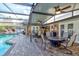 Spacious screened patio with ample seating, ceiling fans, outdoor kitchen area, and a view of the inviting pool at 680 Cheoy Lee Cir, Winter Springs, FL 32708