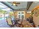 Inviting covered patio with brick pavers, ceiling fan, television, and outdoor dining set overlooking the refreshing pool at 680 Cheoy Lee Cir, Winter Springs, FL 32708