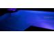 Night view of the in-ground pool illuminated with blue lights at 680 Cheoy Lee Cir, Winter Springs, FL 32708