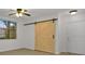 A bright bedroom featuring a barn door, large window, and modern ceiling fan at 710 Siena Palm Dr # 104, Celebration, FL 34747