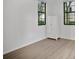 This bedroom has light wood-look floors, a white closet, and two windows for natural light at 710 Siena Palm Dr # 104, Celebration, FL 34747