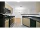 A modern kitchen featuring stainless steel appliances and light wood cabinets at 710 Siena Palm Dr # 104, Celebration, FL 34747
