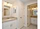 Well-lit bathroom showcasing granite countertops, white cabinets, and a framed mirror for added elegance at 7104 Olympia Ct # 7104, Longwood, FL 32779