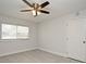 Neutral bedroom features a ceiling fan, window, and tile flooring, offering a blank canvas for personalization at 7104 Olympia Ct # 7104, Longwood, FL 32779