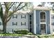 Multi-Gathering condo building with blue and gray facade, balcony, and lush, mature landscaping at 7104 Olympia Ct # 7104, Longwood, FL 32779