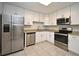 Modern kitchen featuring stainless steel appliances, granite counters, tile flooring and white cabinets at 7104 Olympia Ct # 7104, Longwood, FL 32779