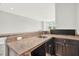 A dark wood finished wet bar featuring granite countertops and a stainless steel sink at 8713 Iron Mountain Trl, Windermere, FL 34786