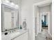 Well-lit bathroom with a granite vanity top, a decorative mirror, and doorways to the hallway and toilet at 8713 Iron Mountain Trl, Windermere, FL 34786
