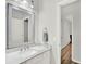 Well-lit bathroom showcasing a vanity with a gray-framed mirror and access to the hallway at 8713 Iron Mountain Trl, Windermere, FL 34786