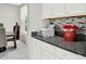A secondary counter space featuring additional cabinetry, granite and decorative backsplash at 8713 Iron Mountain Trl, Windermere, FL 34786