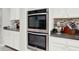 Stainless steel double oven with white cabinets and granite countertops makes cooking and baking simple at 8713 Iron Mountain Trl, Windermere, FL 34786