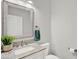 Modern powder room featuring a stone counter, decorative mirror, and updated fixtures at 8713 Iron Mountain Trl, Windermere, FL 34786