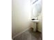 Stylish half bath with a pedestal sink, elegant mirror, and tiled floors at 9033 Alba Ln, Kissimmee, FL 34747