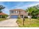 Two-story home with blue shutters, a blue front door, and a well-maintained front lawn at 1033 Sabine Pl, Kissimmee, FL 34759