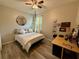 This bedroom features a ceiling fan, mirror, double bed, wood floors, and wooden desk at 113 San Mardeen Ct, Daytona Beach, FL 32117
