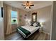 This bedroom features a ceiling fan, a double bed, wood floors, and a window with curtains at 113 San Mardeen Ct, Daytona Beach, FL 32117