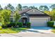 Charming single-story home with stone accents, manicured landscaping, and an attached two-car garage at 113 San Mardeen Ct, Daytona Beach, FL 32117