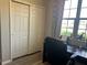 This office space features a large window, wood floors, and a closet with folding doors at 113 San Mardeen Ct, Daytona Beach, FL 32117