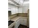 Kitchen featuring white cabinets, neutral countertop and appliances at 120 Hibiscus Woods Ct # 11B, Deltona, FL 32725
