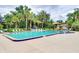 Community pool area surrounded by lounge chairs and lush landscaping at 120 Hibiscus Woods Ct # 11B, Deltona, FL 32725