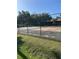 Outdoor tennis court enclosed by a chain link fence and lush landscaping at 120 Hibiscus Woods Ct # 11B, Deltona, FL 32725