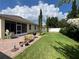 Backyard featuring an enclosed lanai, green grass, and some patio furniture at 12728 Boggy Pointe Dr, Orlando, FL 32824
