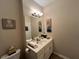 Bathroom featuring a white vanity with a sink, mirror, and tiled floors and neutral color palette at 12728 Boggy Pointe Dr, Orlando, FL 32824