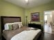 Stylish bedroom with green walls, a comfortable bed, decorative artwork, and an open doorway at 12728 Boggy Pointe Dr, Orlando, FL 32824