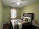 Inviting bedroom with neutral walls, plush bedding, decorative pillows, and a window with natural light at 12728 Boggy Pointe Dr, Orlando, FL 32824