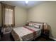 Bedroom with a neutral color scheme, patterned bedding, two side tables, and natural light from a window at 12728 Boggy Pointe Dr, Orlando, FL 32824