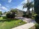 Charming house with a brick driveway and lush landscaping, showcasing vibrant greenery and curb appeal at 12728 Boggy Pointe Dr, Orlando, FL 32824