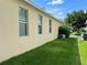View of home exterior featuring manicured lawn, stucco wall, and windows with lawn at 12728 Boggy Pointe Dr, Orlando, FL 32824
